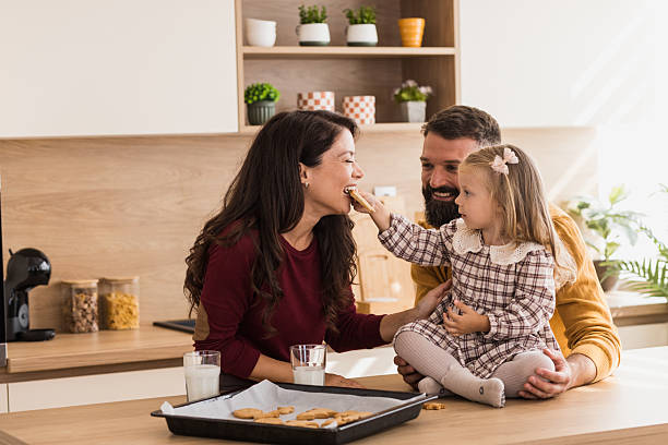 istock Little girl feeding her mom with a gingerbread cookie 2244962043