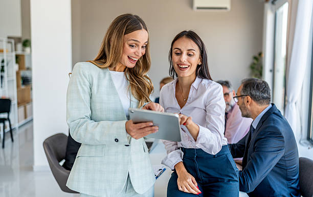 istock Businesswomen smiling while collaborating on digital tablet in office 2244964360