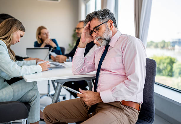 istock Mature businessman feeling stressed at corporate meeting 2244964807