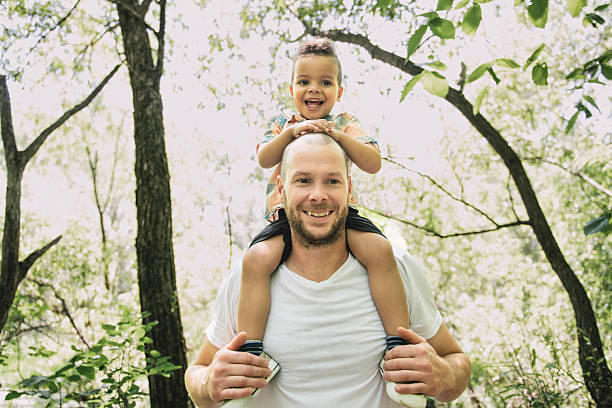 istock father with her son on his shoulder in the forest. 2244964948