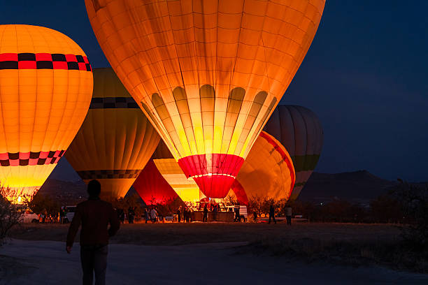 Silhouette of the hot air balloon in Göreme in the morning and the tourists inside