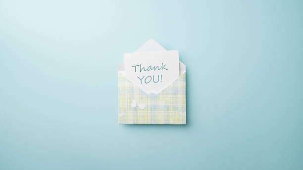 istock Thank you, message on white note card with blue, white, green and yellow plaid envelope on a matching blue background. 2244966291