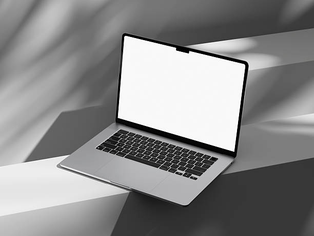 Laptop with a clean screen and shadows of greenery nearby