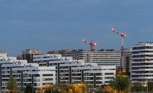Madrid. Spain. Modern residential buildings and active construction cranes shaping the urban skyline, reflecting ongoing city development and economic growth against a twilight sky