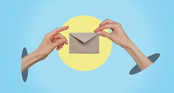 istock A hand holding an envelope with a yellow background 2244971485