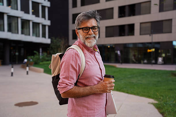 istock Senior businessman outdoors holding coffee and laptop 2244972369