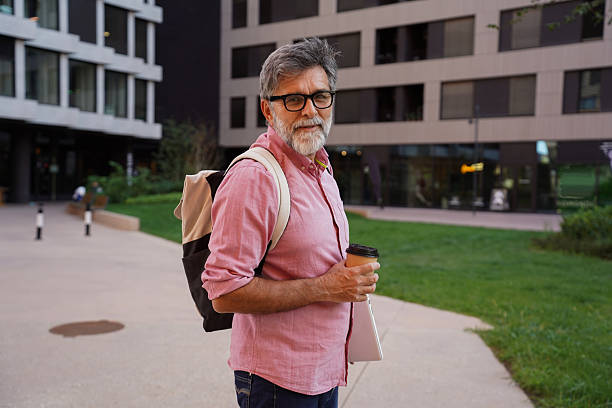 istock Senior businessman outdoors holding coffee and laptop 2244972374