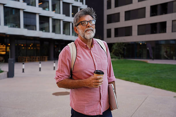 istock Senior businessman outdoors holding coffee and laptop 2244972380