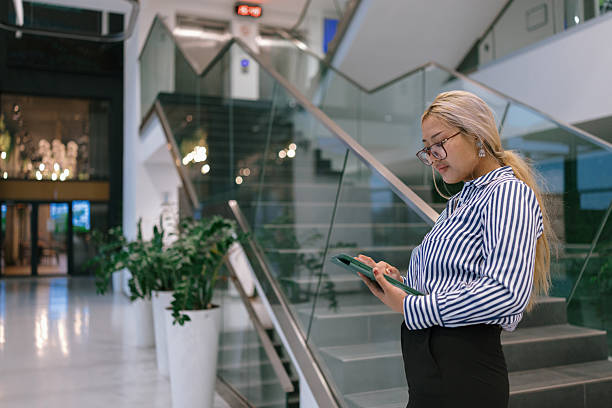 istock Confident woman working on tablet in office lobby 2244973658