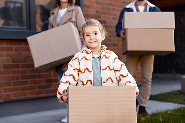 istock Family moving into new home carrying cardboard boxes 2244973671