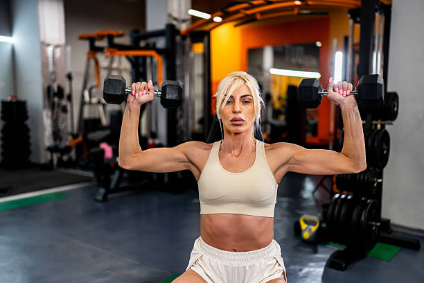 istock Woman exercising with dumbbells during gym workout 2244973747