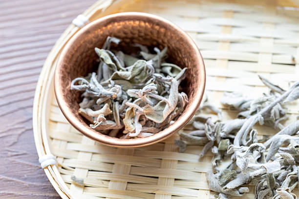 Close-up of a traditional Turkish herbal sage tea served in a rustic copper pot, placed on a wooden table. The warm tones and natural textures highlight the cultural and relaxing atmosphere, ideal for visuals focused on traditional drinks, herbal wellness, tea rituals, or Turkish culture.