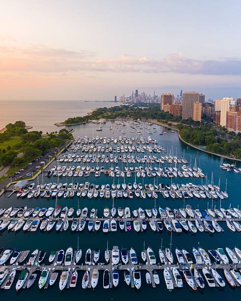 Dramatic aerial view of boats docked at Montrose Harbor in front of the Chicago skyline at dawn.