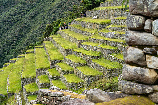 Aguas Calientes, Peru - March 18, 2025: Tourists visiting the ancient Inca terraces at Machu Picchu, Peru.