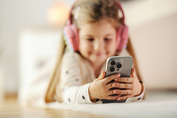 istock Young girl wearing headphones using smartphone at home 2244982952