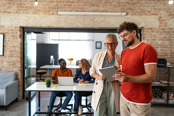 istock Diverse business professionals collaborating in a modern office using a tablet 2244983583