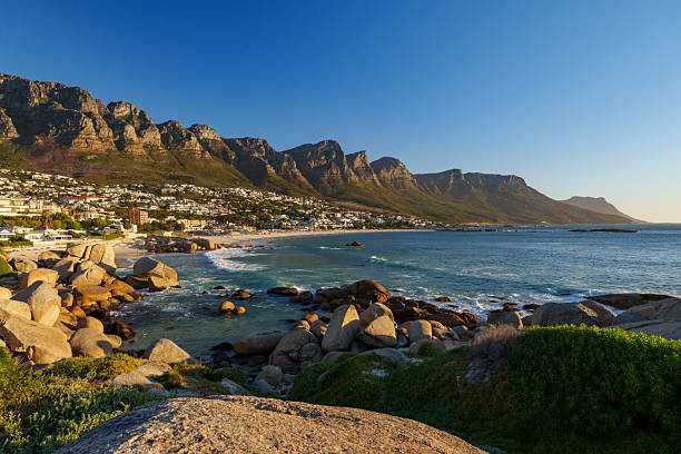 istock Breathtaking panoramic view of Camps Bay's white sandy beach and  Atlantic Ocean, framed by the majestic Twelve Apostles mountain range in the background. Cape Town, Western Cape, South Africa. 2244985312