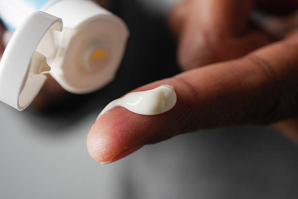 istock Hand applying moisturizing cream in a close-up view 2244985396