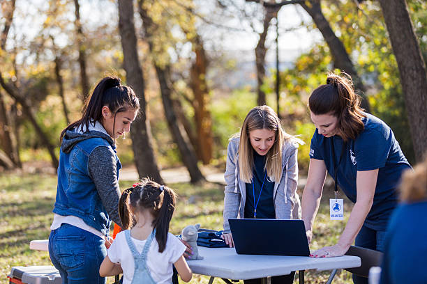istock Diverse group of volunteers collaborating outdoors on a project using a laptop. 2244985445