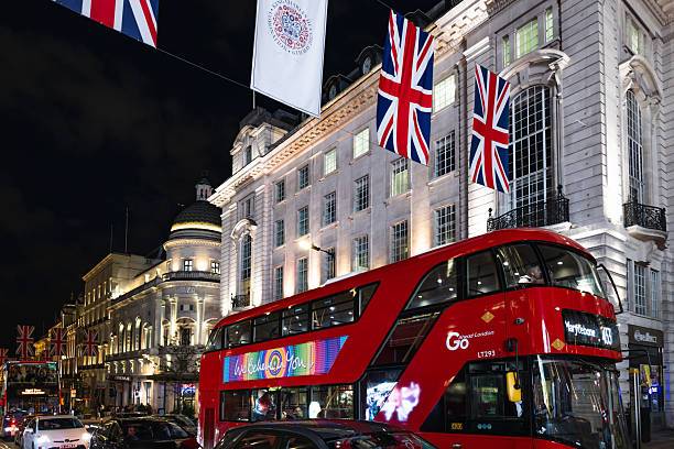 London typical red bus blurred motion at night in Oxford Circus