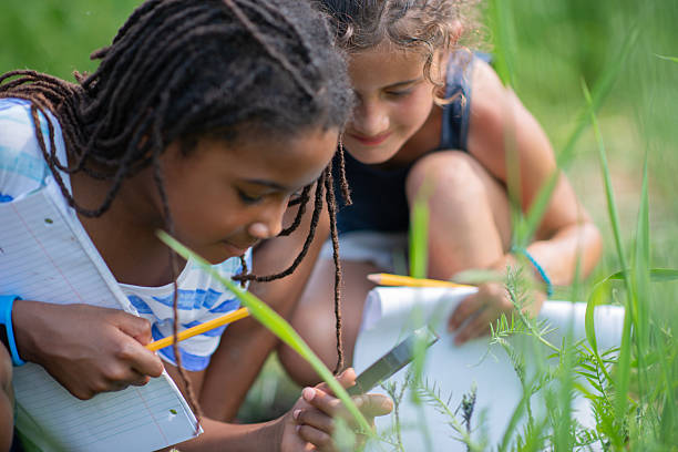 istock Outdoor Science Learning With Two Kids Reading Notebooks And Pencils In Grass 2244988482