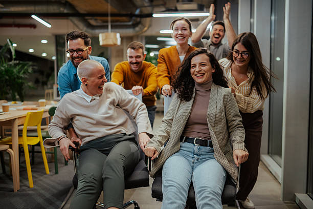 istock Coworkers having fun racing desk chairs in modern office 2244988806