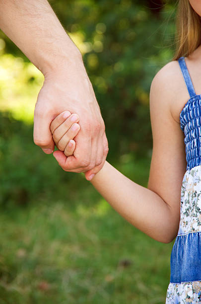 istock father holding  daughter hand 2244990400