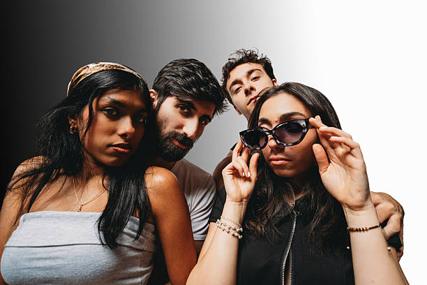 istock Diverse young adults posing confidently with sunglasses against gradient 2244990707