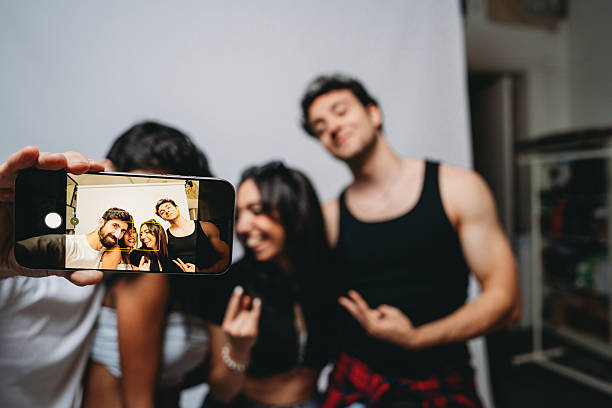 istock Young friends taking selfie using smartphone at home party 2244990724