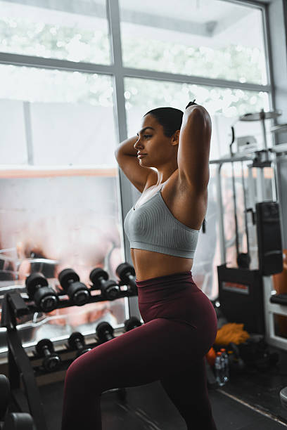 istock Fit Woman In Gym Performs Core Workout With Weights And Natural Light 2244991994