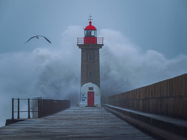 Mighty waves in the English channel overwhelm Newhaven harbour lighthouse, East Sussex. UKColour image but look monochrome