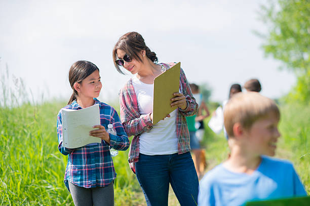 istock Outdoor Science Field Day: Diverse Students Learn Together With Notebooks On a Sunny Path 2244996108