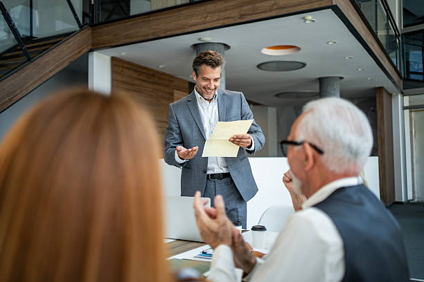 istock Businessman making presentation receiving applause in office meeting 2245002427