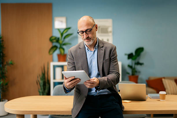 istock Mature businessman using tablet in modern office 2245004569