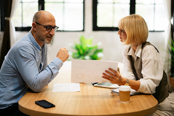 istock Business colleagues analyzing report during meeting in office 2245004695