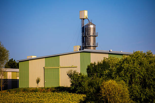 A picturesque scene featuring a grain silo standing tall amidst golden wheat fields on a sunny summer day. This photo captures the essence of rural agriculture and the beauty of the farming landscape.