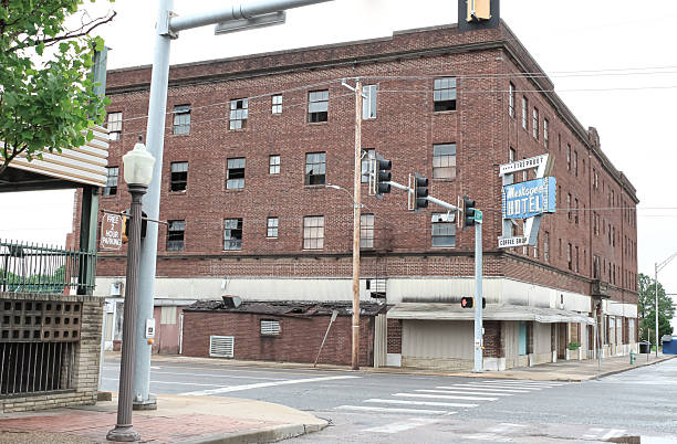A street corner in Muskogee, Oklahoma with an abandoned hotel building with a neon sign on the corner