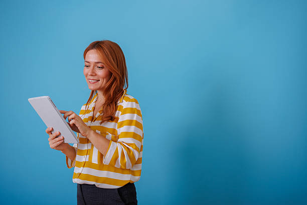 istock Smiling woman using digital tablet for online learning, social media, shopping, or browsing content 2245010470