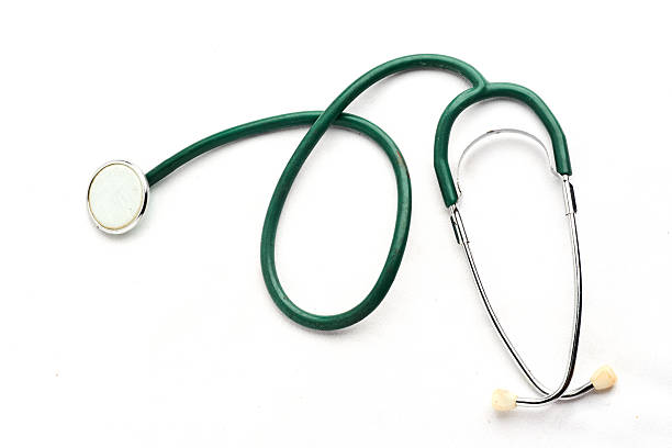 A neatly coiled stethoscope rests on a pristine studio surface, metal chestpiece forward, evoking training, calm assessment, and the quiet routine of clinical listening.