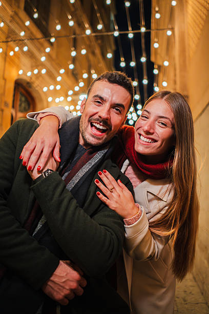 istock Joyful couple celebrating love and happiness while embracing each other with bright smiles and laughter in a charming nighttime filled with sparkling lights and delightful moments shared together 2245012987
