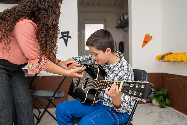 istock Guitar teacher adjusting a young student’s right-hand techniqu 2245015761