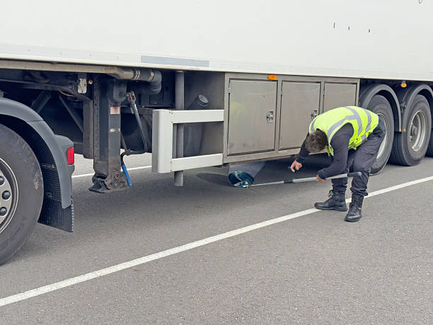 Truck driver checks under lorries for Illegal Immigrants
