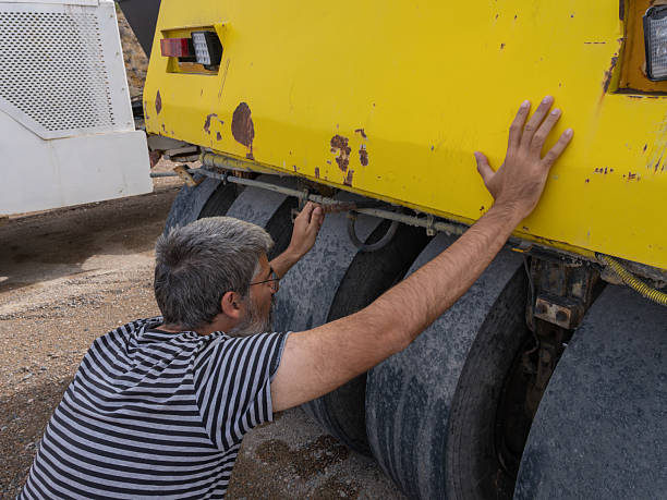 istock Mechanic inspecting road roller wheels and undercarriage 2245019321