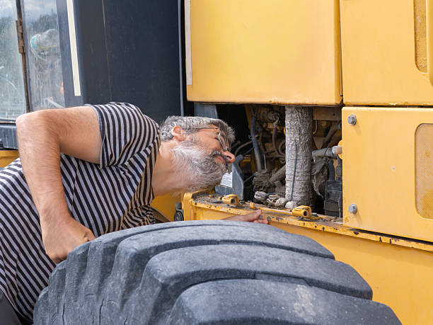 istock Mechanic inspecting heavy machinery engine compartment outdoors 2245020724