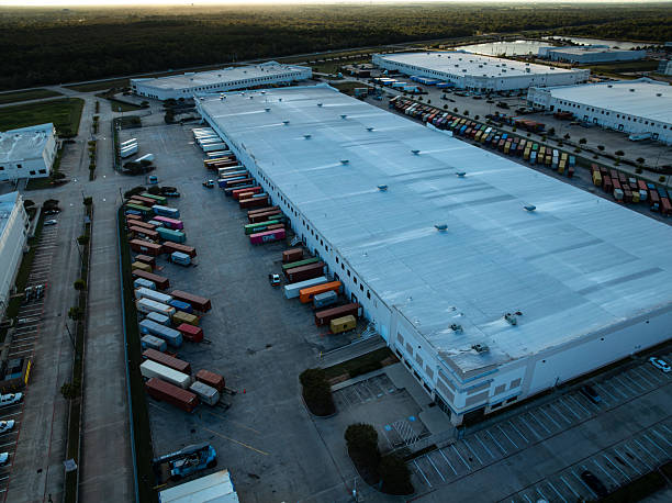 Wide aerial shot of complex of distribution centers surrounded by trucks in Pasadena, Texas after sunset on a fall evening.