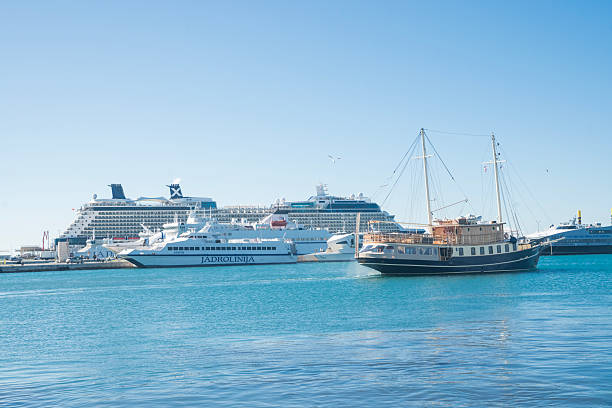 Harbor skyline of Oslo Norway seen from the opera area, with calm blue water and passenger ships on a bright summer day