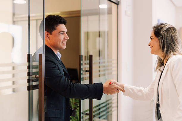 istock Coworkers shaking hands in office hallway 2245039096