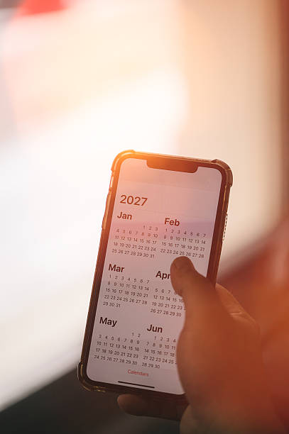 istock Concept for time management and financial planning reminder 2027. man using smartphone working with year 2027 calendar, business planning marketing and investment 2245040101
