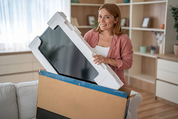 istock An online shopper lifts her new purchase from its box 2245045775