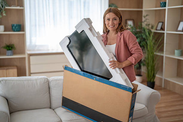 istock An online shopper lifts her new purchase from its box 2245045779